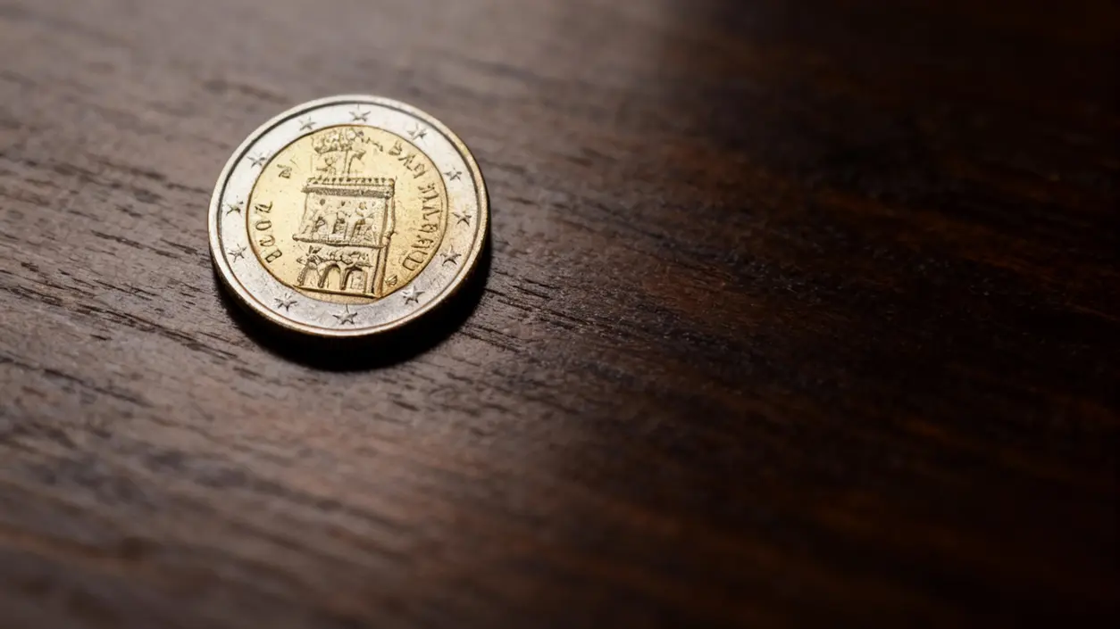 Moneta da 2 euro di San Marino poggiata su una superficie in legno