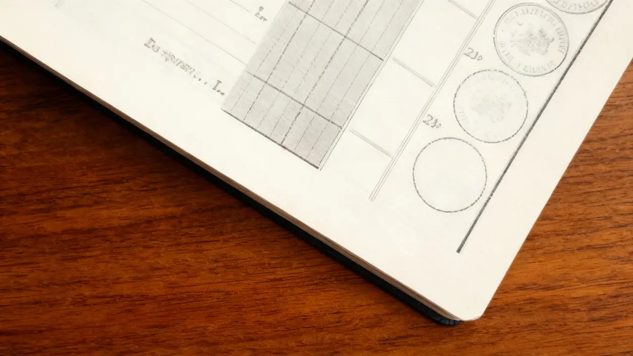 Dettaglio di un libretto postale aperto su un tavolo in legno