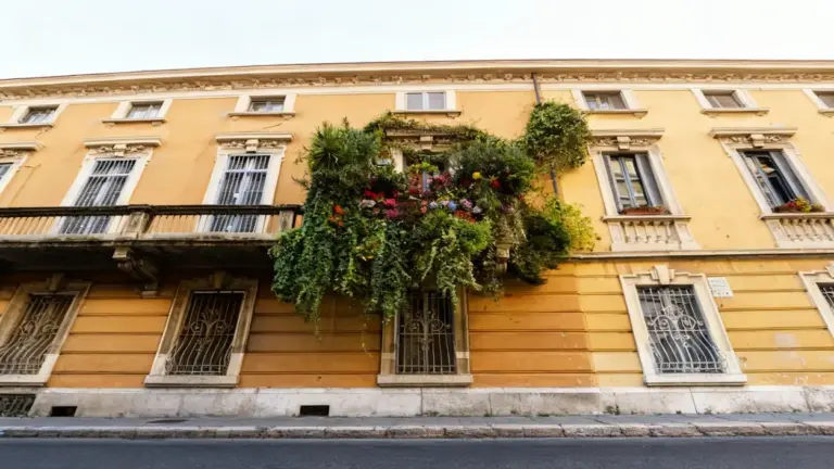 Balcone di un edificio con piante ornamentali e rampicanti rigogliose