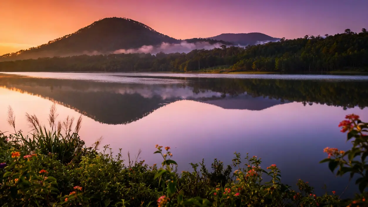 Paesaggio naturale con lago calmo, montagne e vegetazione al tramonto