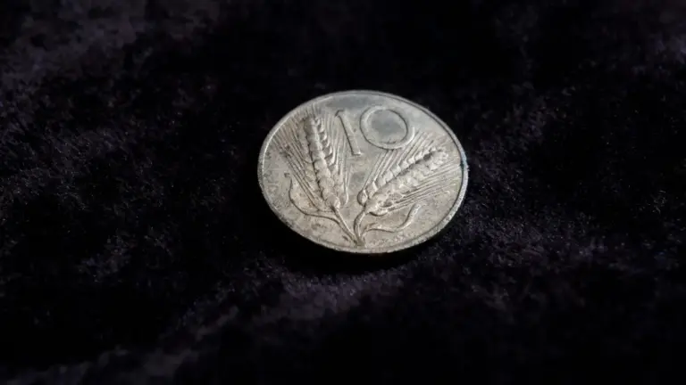 Vecchia moneta italiana da 10 lire con spiga su sfondo scuro