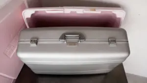 Vecchia valigetta metallica argentata appoggiata su un tavolo