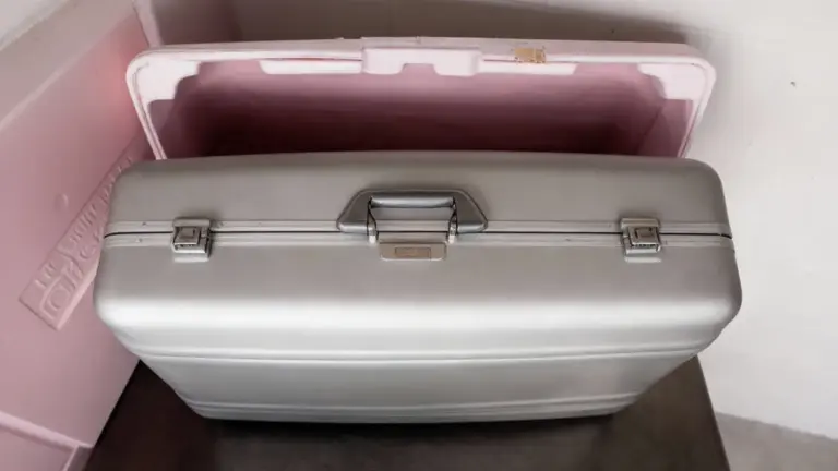 Vecchia valigetta metallica argentata appoggiata su un tavolo